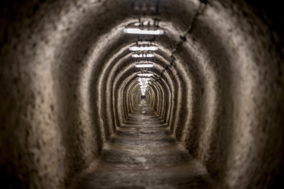 People walk in an access gallery at the Salina Turda, a former salt mine turned touristic attraction, now listed by emergency authorities as a potential civil defense shelter in Turda, central Romania, Monday, Oct. 17, 2022. Fighting around Ukraine's nuclear power plants and Russia's threats to use nuclear weapons have reawakened nuclear fears in Europe. This is especially felt in countries near Ukraine, like Poland, where the government this month ordered an inventory of the country's shelters as a precaution. (AP Photo/Vadim Ghirda)