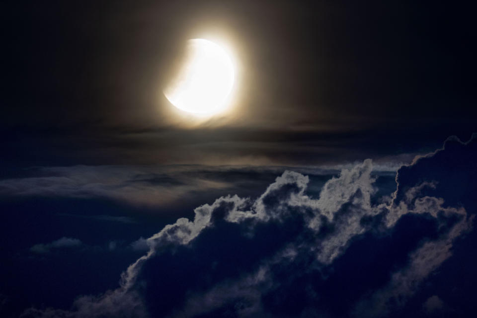 A lunar eclipse begins as the full moon sets over the hills of the Taunus mountains near Frankfurt, Germany, Monday, May 16, 2022. (AP Photo/Michael Probst)