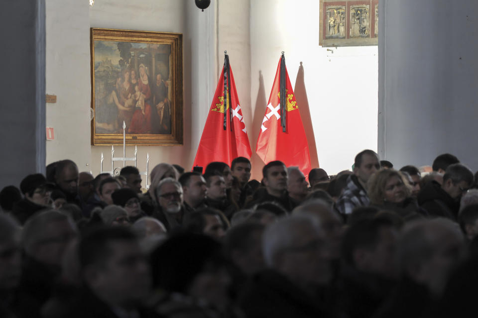 Gdansk city flags with black mourning sashes at St. Mary's Basilica during the funeral Mass of the city's slain Mayor Pawel Adamowicz that is attended by Poland's and European officials, in Gdansk, Poland, on Saturday, Jan 19, 2019. Adamowicz died Monday after being stabbed the night before at a charity event by an ex-convict with a grudge against an opposition party that Adamowicz once belonged to. (AP Photo/Wojtek Strozyk)