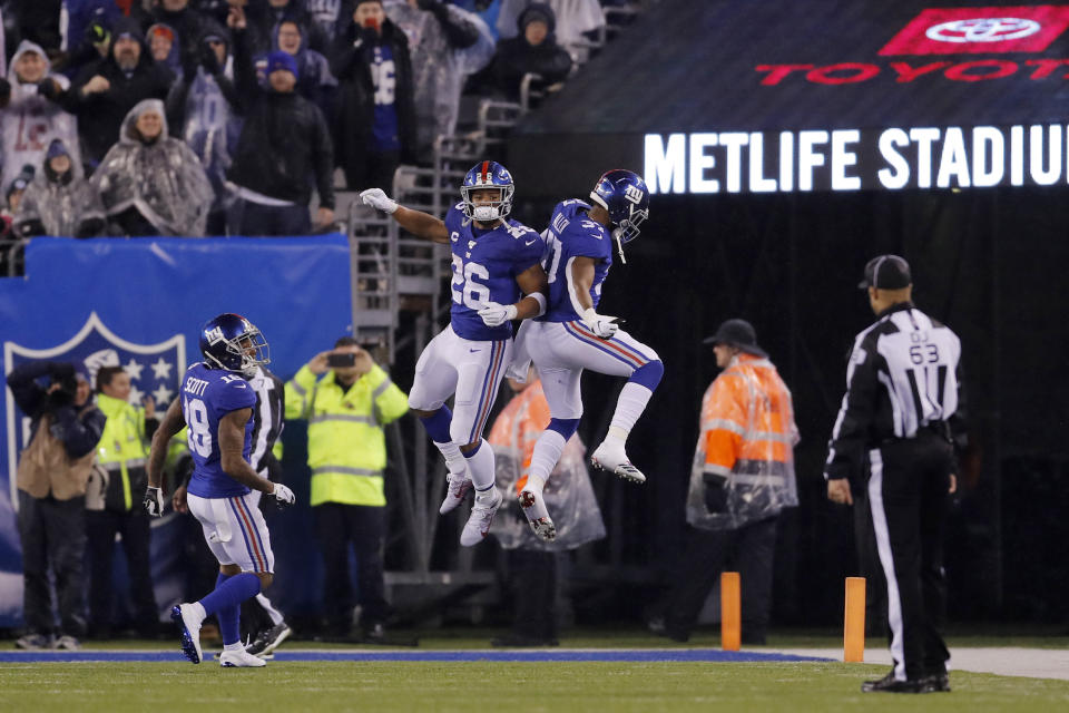 New York Giants running back Saquon Barkley (26) celebrates a touchdown with Giants running back Javorius Allen (37) in the second half of an NFL football game against the Philadelphia Eagles, Sunday, Dec. 29, 2019, in East Rutherford, N.J. (AP Photo/Adam Hunger)