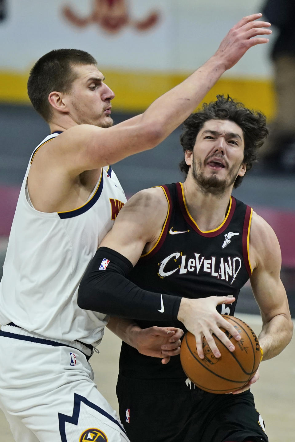 Cleveland Cavaliers' Cedi Osman, right, drives as Denver Nuggets' Nikola Jokic defends during the first half of an NBA basketball game Friday, Feb. 19, 2021, in Cleveland. (AP Photo/Tony Dejak)