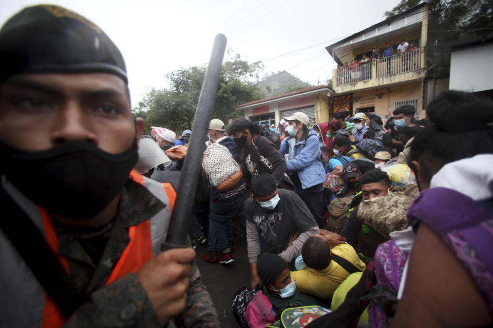 Honduran migrants hoping to reach the U.S. cross the border patrolled by Guatemalan soldiers, in El Florido, Guatemala, Saturday, Jan. 16, 2021. Honduran migrants pushed their way into Guatemala Friday night without registering, a portion of a larger migrant caravan that had left the Honduran city of San Pedro Sula before dawn, Guatemalan authorities said. (AP Photo/Sandra Sebastian)