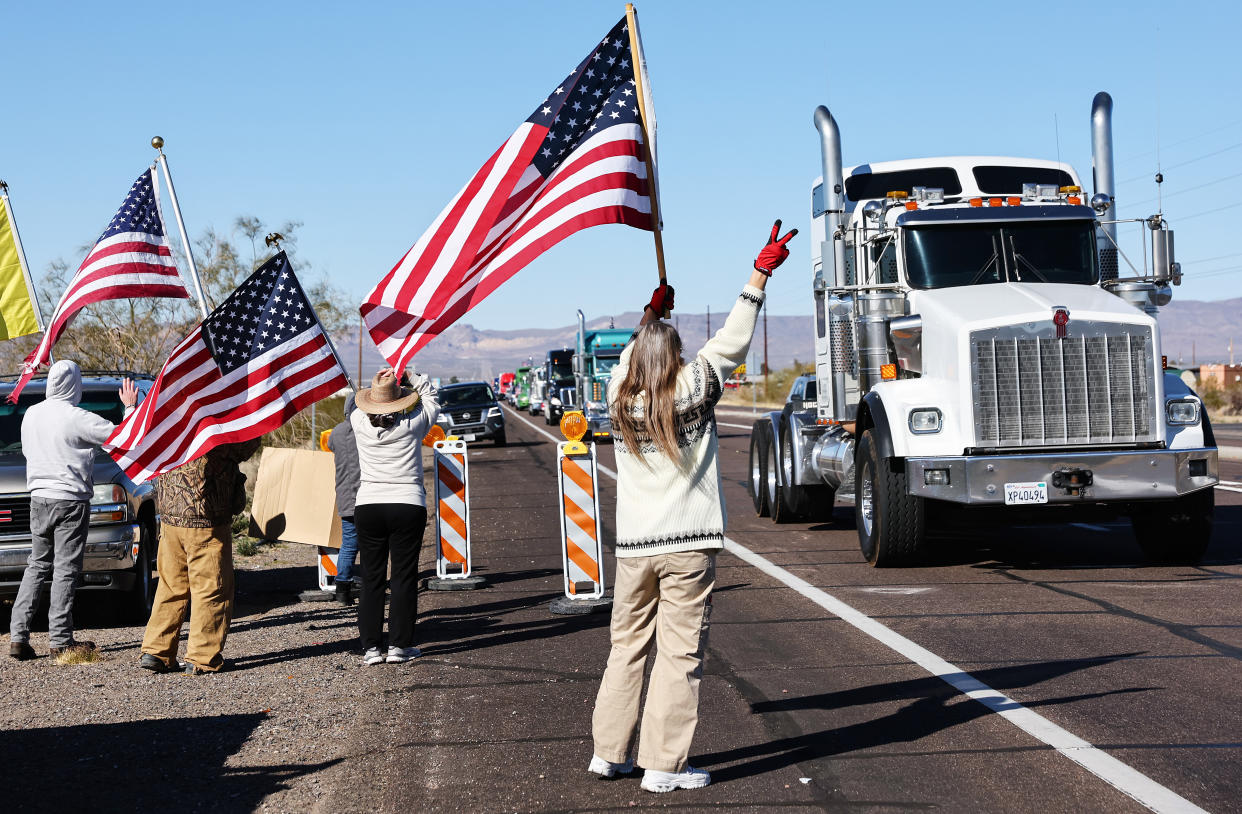 Supporters wave at truckers on a cross-country trip to protest COVID-19 mandates