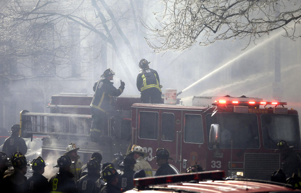 ADDS LAST SENTENCE - Fighters battle a multi-alarm fire at a four-story brownstone in the Back Bay neighborhood near the Charles River, Wednesday, March 26, 2014, in Boston. A Boston city councilor said two firefighters have died in a fire that ripped through a brownstone. (AP Photo/Steven Senne)