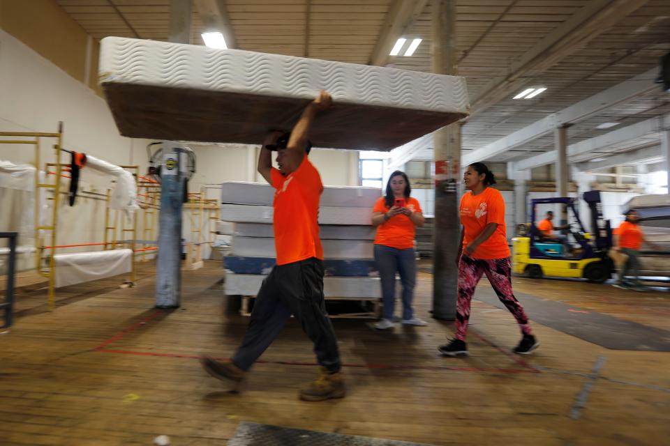 Workers select some mattresses which will be re-sold after being upcycled at the HandUp Mattress Recycling & Upcycling facility at the Kilburn Mill in New Bedford.