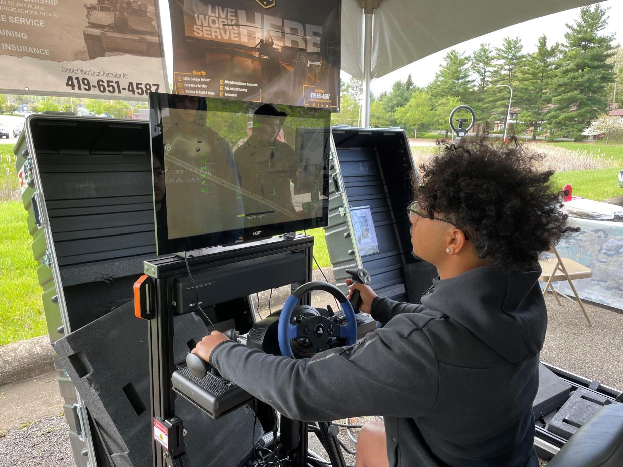 Newark senior Kameron Gates tries out a simulator at the Ohio Army National Guard booth during a skilled trades celebration at the former State Farm building.