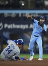 Toronto Blue Jays second baseman Isiah Kiner-Falefa (7) forces out Kansas City Royals' Freddy Fermin (34) at second base and throws to first to complete the double play during the fifth inning of a baseball game, Tuesday, April 30, 2024 in Toronto.(Nathan Denette/The Canadian Press via AP)