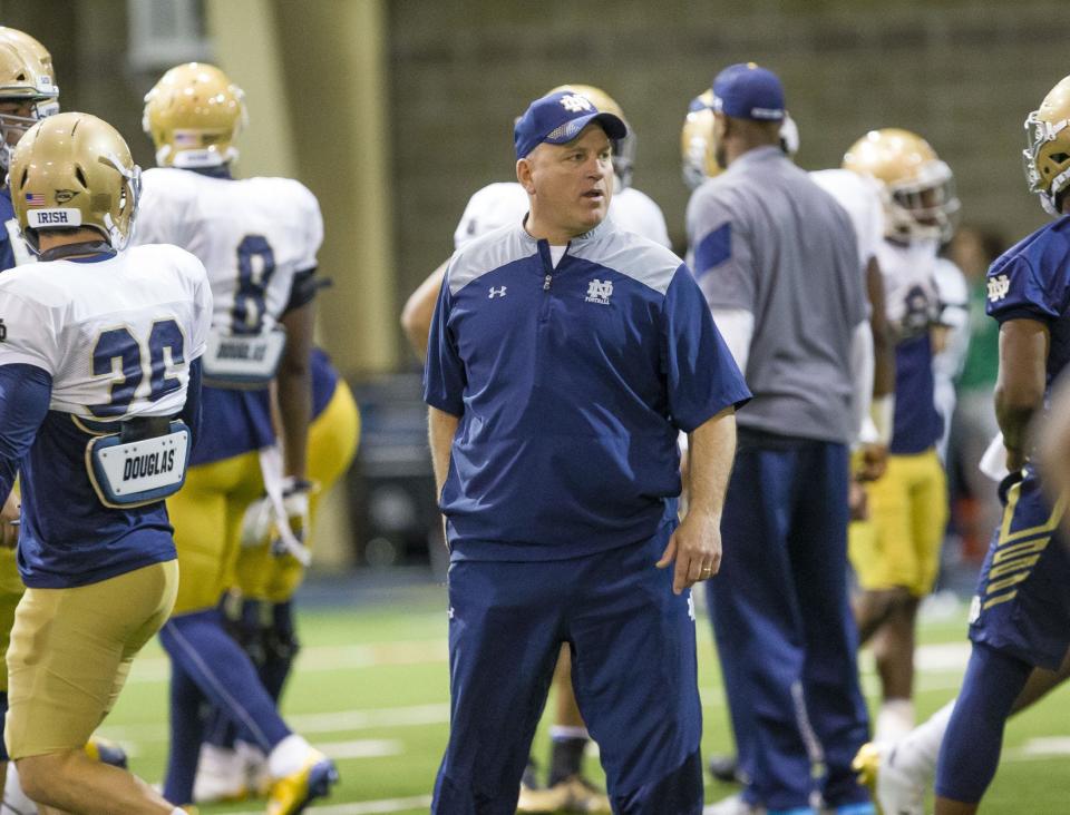 Notre Dame offensive line coach Jeff Quinn watches as players warm at recent spring practice inside the Loftus Center.