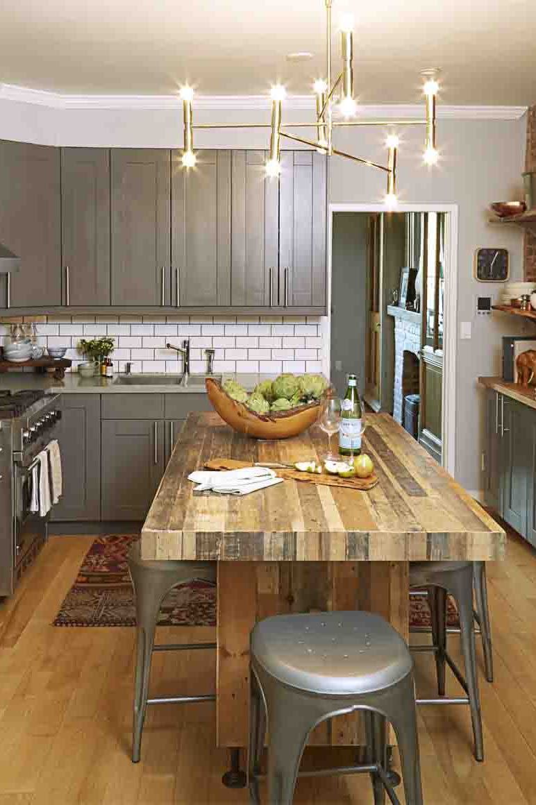 <p>A white subway tile backsplash tempers this kitchen's deep gray cabinets and wood island. It's a simple touch that blends in with any design style. </p>
