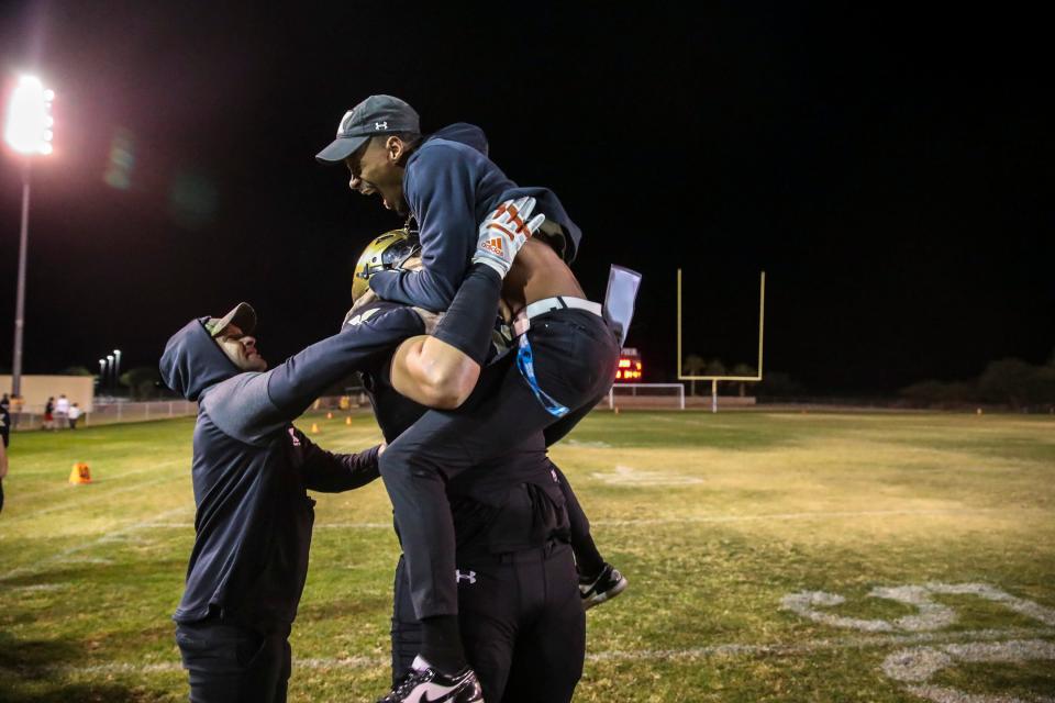Xavier Prep head coach James Dockery jumps into the arms of lineman Elijah Vaikona in celebration of winning their second-round playoff game at Xavier College Preparatory High School in Palm Desert, Calif., Friday, Nov. 10, 2023.