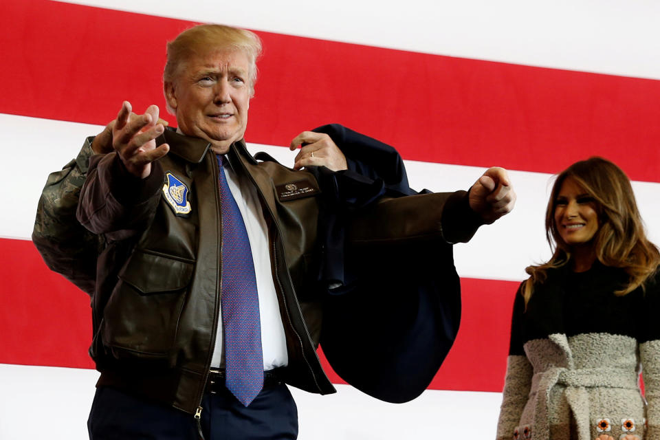 President Donald Trump puts on a U.S. Pacific Air Forces bomber jacket before delivering remarks to members of the U.S. military at Yokota Air Base, Japan.