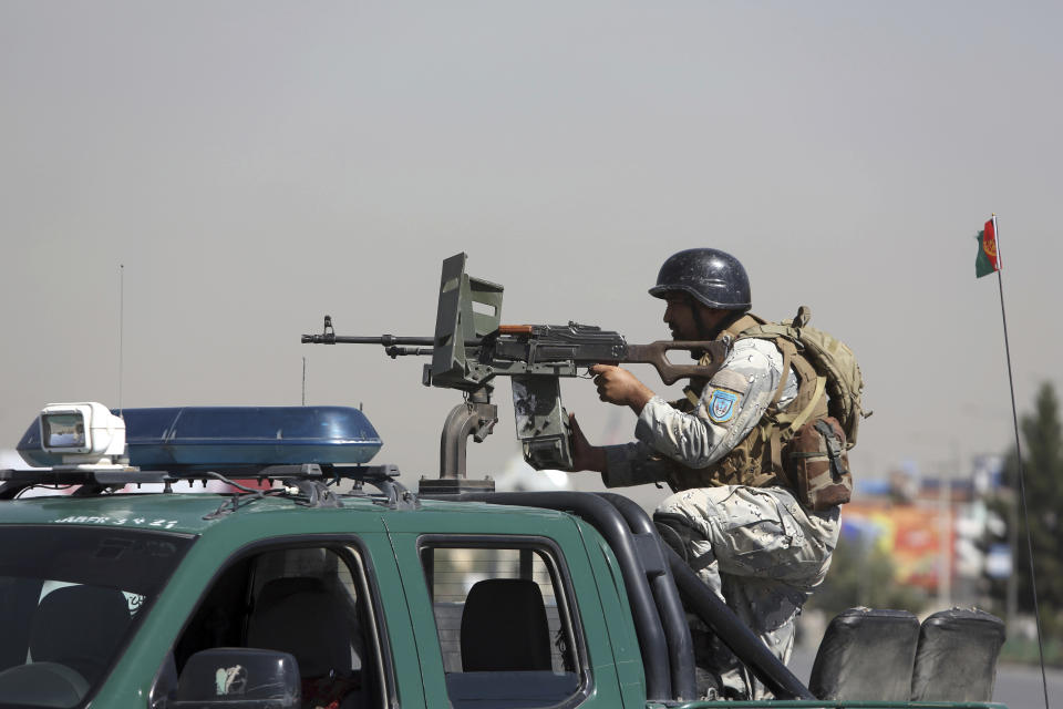 An Afghan security officer mans with gun near a house where attackers are hiding, in Kabul, Afghanistan, Tuesday, Aug. 21, 2018. Afghan police say the Taliban fired rockets toward the presidential palace in Kabul as President Ashraf Ghani was giving his holiday message for the Muslim celebrations of Eid al-Adha. (AP Photo/Rahmat Gul)