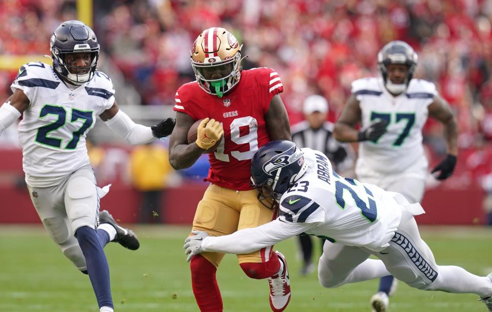 San Francisco 49ers wide receiver Deebo Samuel (19) is defended by Seattle Seahawks safety Johnathan Abram (23) and cornerback Tariq Woolen (27) in the third quarter of a wild card game at Levi's Stadium.