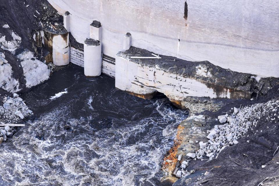 Water flowing out of an opening in the bottom of a large dam