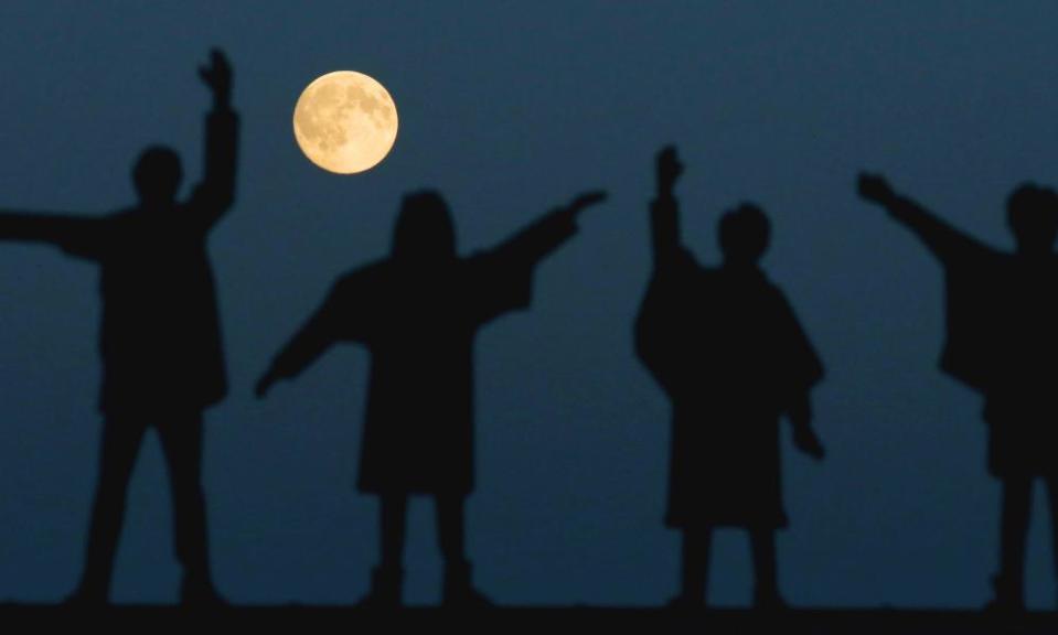 A full moon over The Beatles statues on Penny Lane, Liverpool.