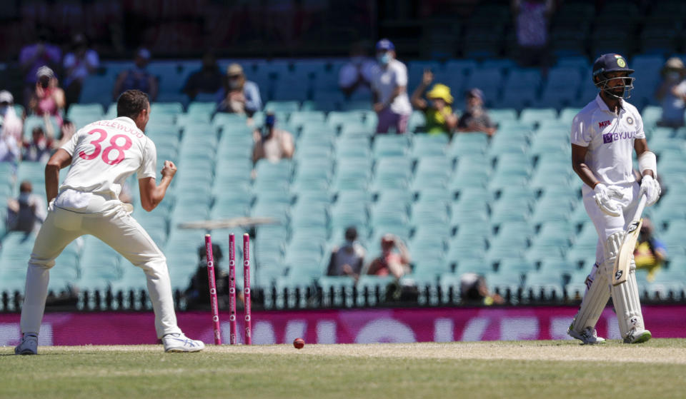 India's Cheteshwar Pujara, right, is out bowled by Australia's Josh Hazlewood, left, during play on the final day of the third cricket test between India and Australia at the Sydney Cricket Ground, Sydney, Australia, Monday, Jan. 11, 2021. (AP Photo/Rick Rycroft)