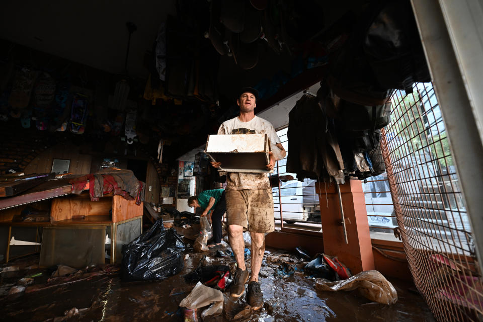 LISMORE, AUSTRALIA - MARCH 02:  Travis Watson throws away flood damaged merchandise from his skate shop on March 02, 2022 in Lismore, Australia. Several northern New South Wales towns have been forced to evacuate as Australia faces unprecedented storms and the worst flooding in a decade. (Photo by Dan Peled/Getty Images)