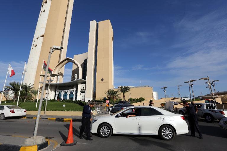 Security officials check a vehicle outside the Corinthia hotel in Tripoli on October 10, 2013