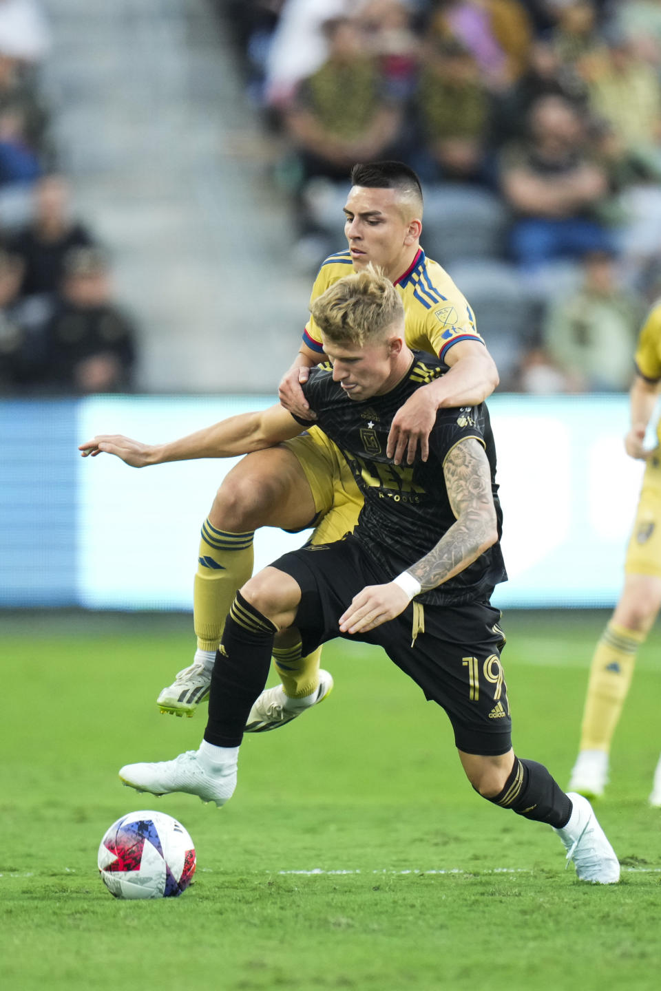 Los Angeles FC midfielder Mateusz Bogusz (19) is grabbed by Real Salt Lake midfielder Braian Ojeda , top,during the first half of an MLS soccer match Sunday, Oct. 1, 2023, in Los Angeles. (AP Photo/Jae C. Hong)