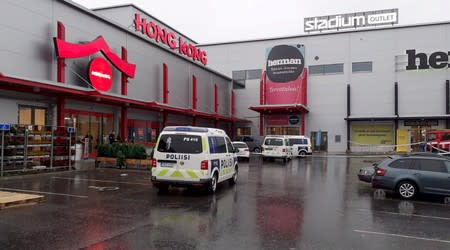 Police vans are seen in front of the Herman shopping center where the Savo Vocational College is located in Kuopio
