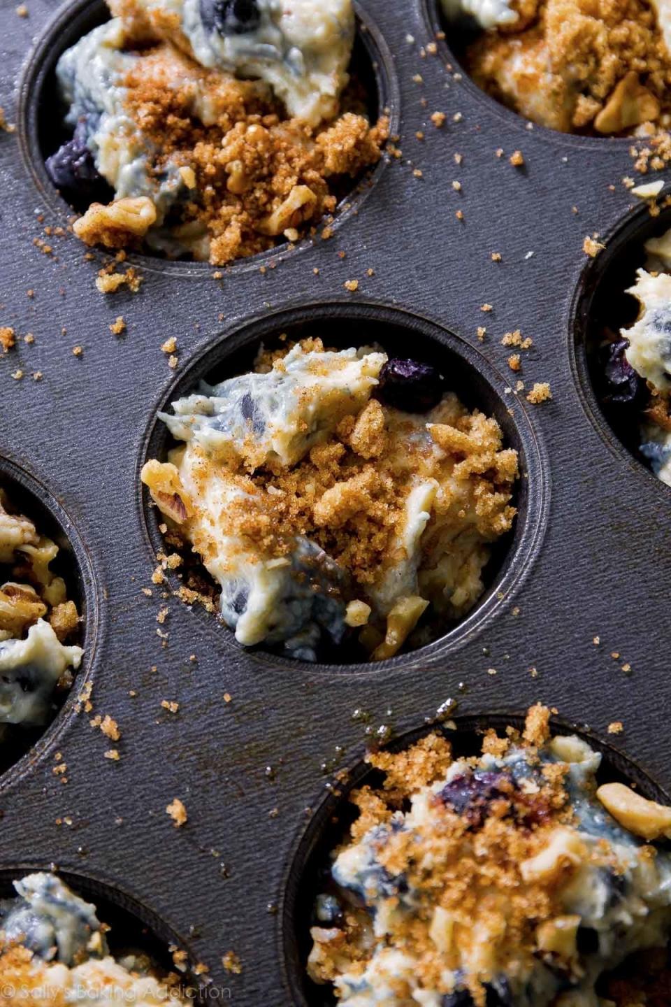 Blueberry muffins in a baking tray topped with crumble