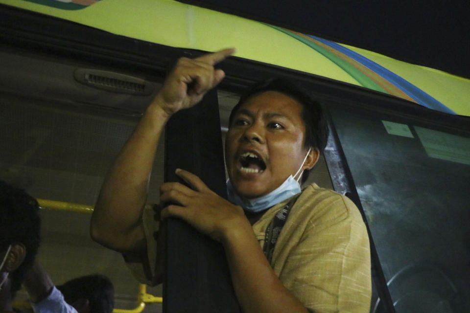 A man gestures while onboard a bus with released prisoners that is being driven out of Insein Prison in Yangon, Myanmar, Wednesday, June 30, 2021. Myanmar's government began releasing about 2,300 prisoners on Wednesday, including activists who were detained for protesting against the military's seizure of power in February and journalists who reported on the protests, officials said. (AP Photo)