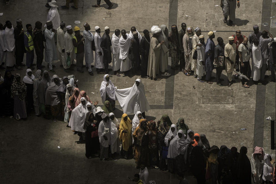 Muslim pilgrims line up in two rows, one for men and one for women, in front of a restaurant outside the Grand Mosque, during the annual hajj pilgrimage, in Mecca, Saudi Arabia, Friday, June 23, 2023. Muslim pilgrims are converging on Saudi Arabia's holy city of Mecca for the largest hajj since the coronavirus pandemic severely curtailed access to one of Islam's five pillars. (AP Photo/Amr Nabil)