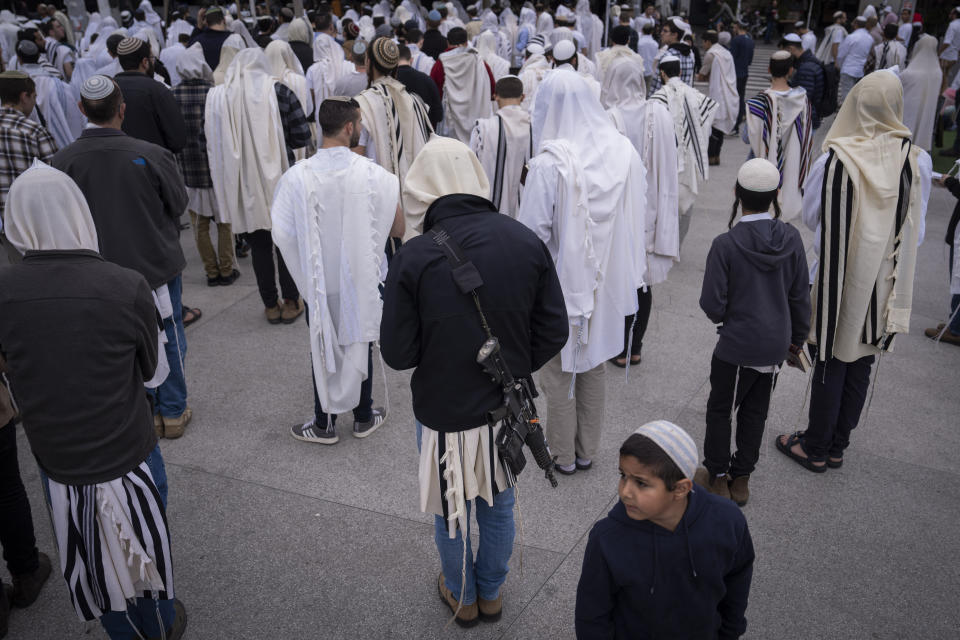 Covered in prayer shawls, Jewish men attend an outdoor prayer and celebrations of the Jewish holiday of Passover, in central Tel Aviv, Israel, Tuesday, April 11, 2023. (AP Photo/Oded Balilty)