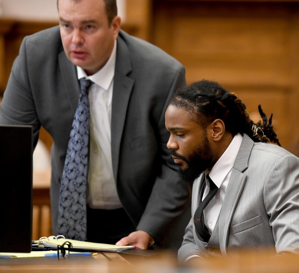 Errol G. Frank III, right, speaks Tuesday with defense attorney Aaron Kovalchik while on trial in Stark County Common Pleas Court. He faces felony charges of murder, felonious assault and tampering with evidence with gun specifications in the death of Melvin Stevenson in March.