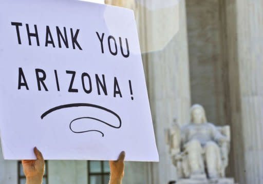 A supporter of Arizona's tough immigration law holds a sign in front of the Supreme Court