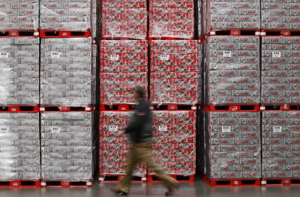 Warehouse manager Chad Sadler walks by cases of Coca-Cola and Diet Coke.
