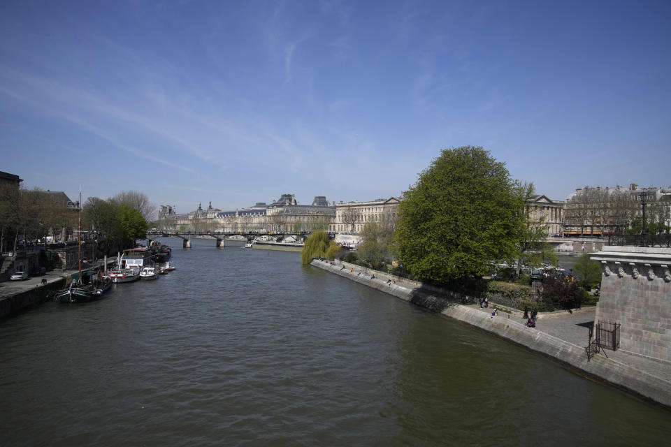 The River Seine flows in Paris, Wednesday, April 5, 2023. A costly and complex clean-up is resuscitating the River Seine just in time for it to play a starring role in the 2024 Paris Olympics. The city and its region are rushing to make the Seine's murky waters swimmable, so it can genuinely live up to its billing as the world’s most romantic river. (AP Photo/Christophe Ena)
