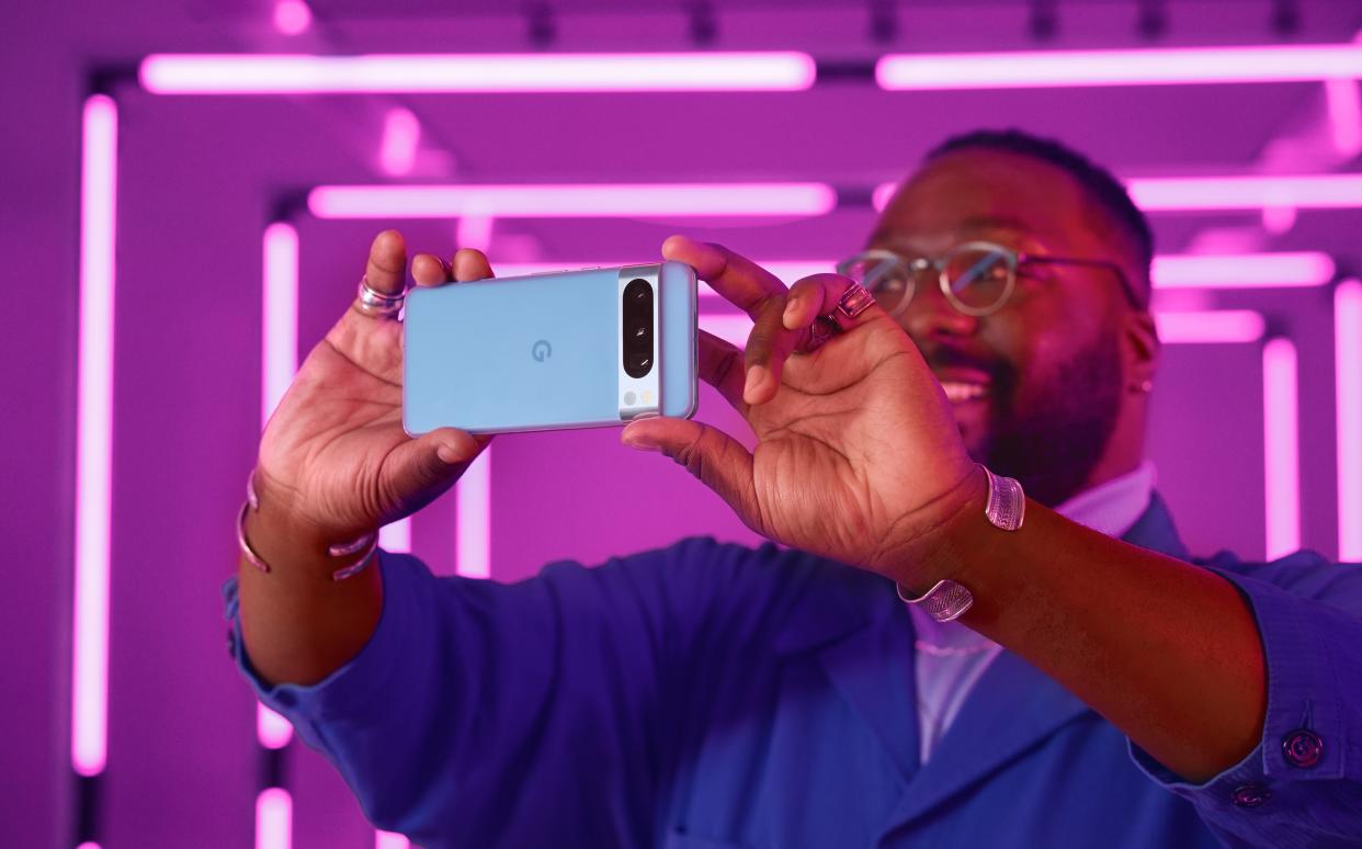  An image of a man holding a Google Pixel 8 Pro. 