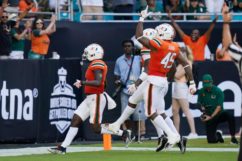 Miami defensive lineman Mitchell Agude (45) celebrates as defensive back Gilbert Frierson, left, scores a touchdown after intercepting the ball during the first half of an NCAA college football game against Bethune Cookman, Saturday, Sept. 3, 2022, in Miami Gardens, Fla. (AP Photo/Lynne Sladky)