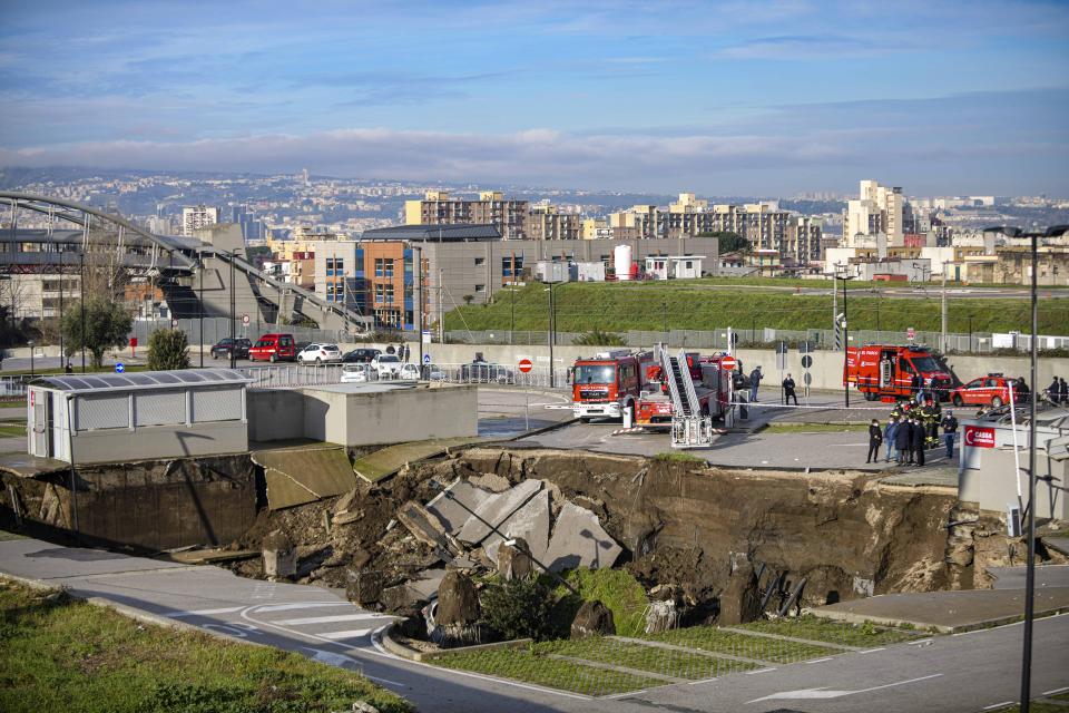 A view of the large sinkhole that opened overnight in the parking of Ospedale del Mare hospital in Naples, Italy, Friday, Jan. 8, 2021. A giant sinkhole opened Friday in the parking lot of a Naples hospital, forcing the temporary closure of a nearby residence for recovering coronavirus patients because the electricity was cut. (Alessandro Pone/LaPresse via AP)