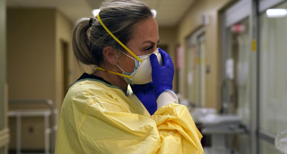 Medical staffer wearing surgical mask looks emotional.