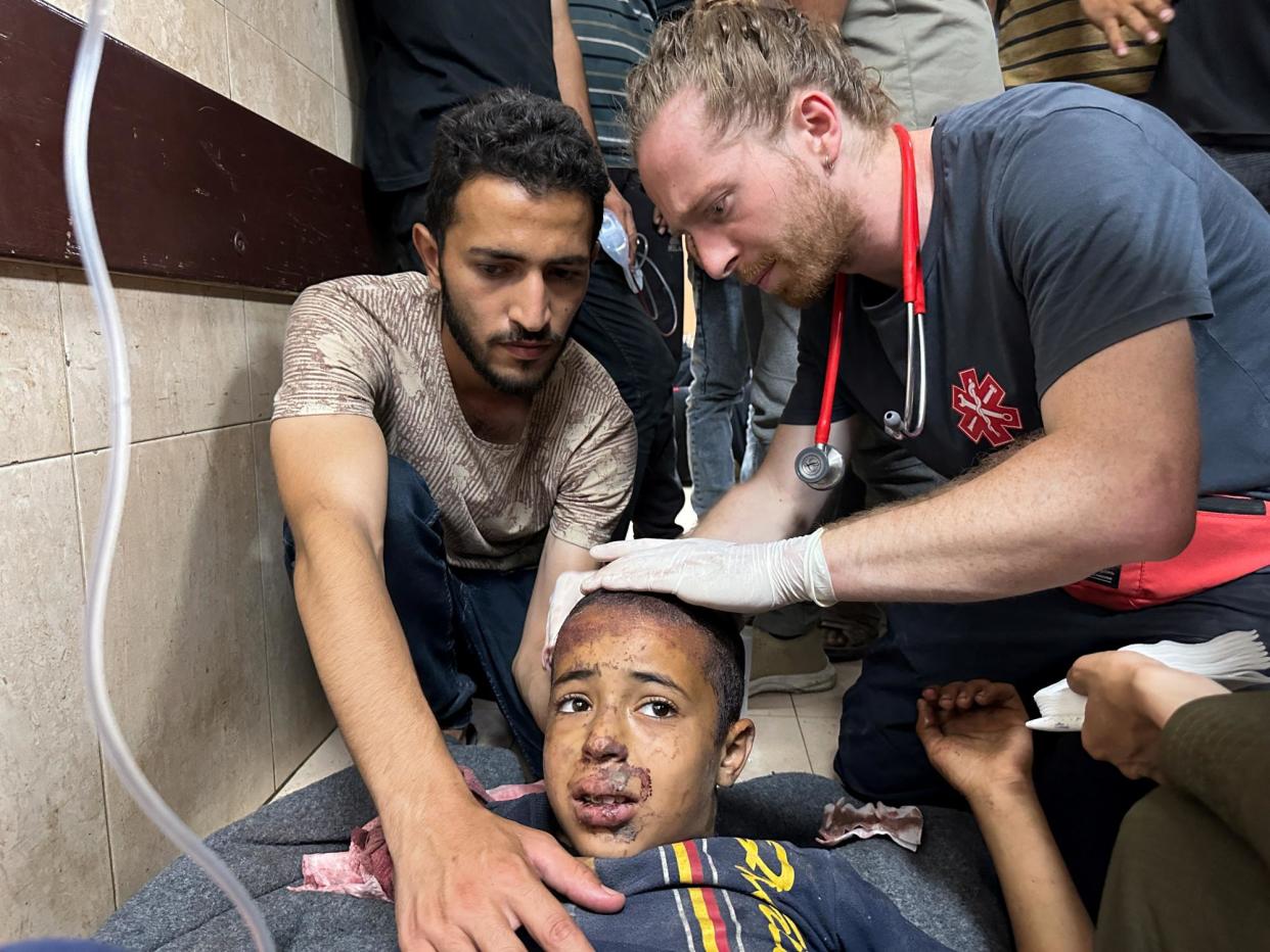 <span>A medic treats a boy wounded by the Israeli strike on a Unrwa school.</span><span>Photograph: Doaa Rouqa/Reuters</span>