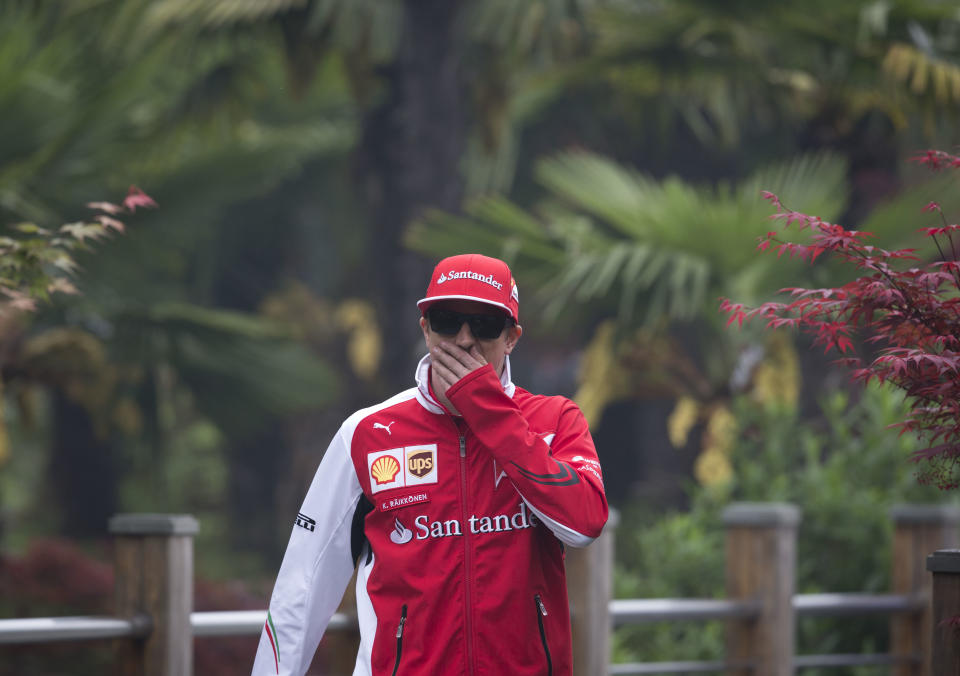 Ferrari driver Kimi Raikkonen of Finland walks on the paddock ahead of Sunday's Chinese Formula One Grand Prix at Shanghai International Circuit in Shanghai, China Thursday, April 17, 2014. (AP Photo/Andy Wong)