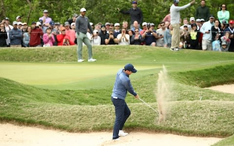 Rory McIlroy is forced to play out of a bunker - Credit: getty images