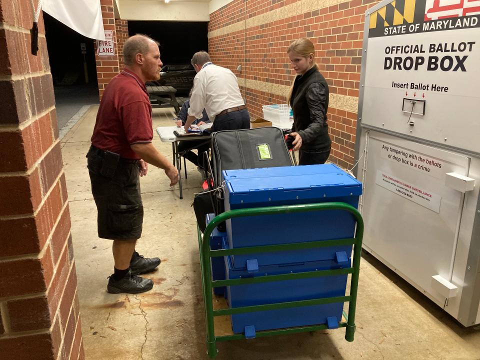 Republican Chief Judge Chip Brown, left, helps deliver Washington County’s first Election Day ballot results from Emma K. Doub Elementary School on Tuesday night. At right is election volunteer Samantha Steckel, and Deputy Elections Director Barry Jackson is handling paperwork.