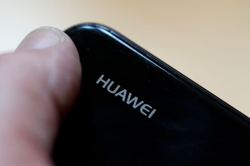 FILE PHOTO: A worker refurbishes a Huawei cell phone at a workshop of the Oxflo company, specialised in refurbishment of broken European smartphones in Lusignac