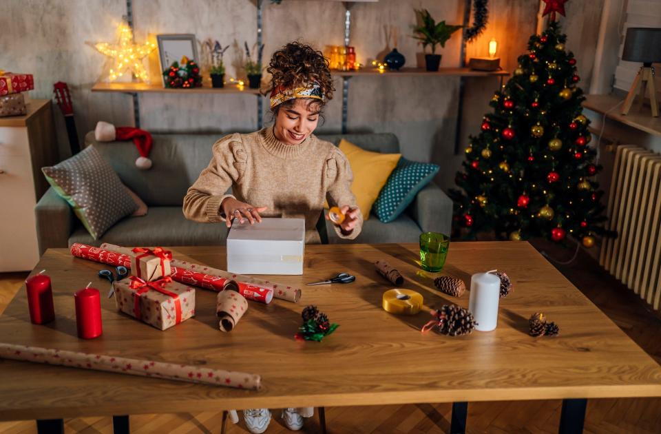 A woman is photographed wrapping gifts