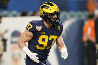 FILE - Michigan defensive end Aidan Hutchinson watches during warm ups before the Orange Bowl NCAA College Football Playoff semifinal game against Georgia, Friday, Dec. 31, 2021, in Miami Gardens, Fla. Jacksonville, which chose Clemson quarterback Trevor Lawrence last year and is expected to add Michigan pass rusher Hutchinson, Georgia's Travon Walker or an offensive tackle next, is looking to become the first to say it nailed both selections. (AP Photo/Lynne Sladky, File)