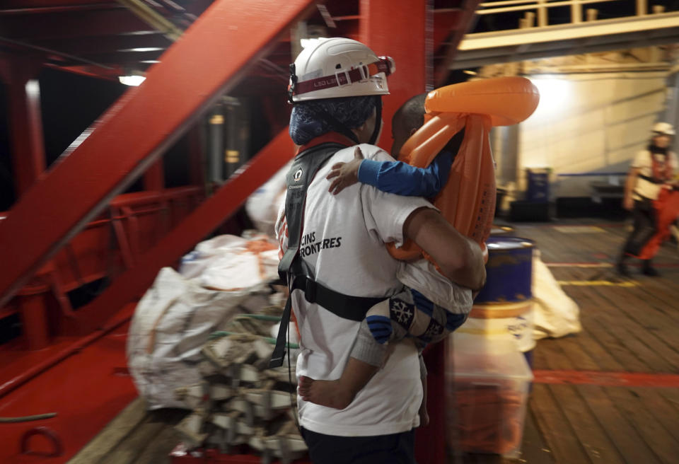 A toddler who was rescued at sea by a 14-meter sailboat Josefa, run by the group Resqship, is carried by a medic after being transferred onto the humanitarian ship Ocean Viking, in the Mediterranean Sea, late Monday, Sept. 9, 2019. Thirty-four migrants including women and the small child who were rescued by the German sailboat have been successfully taken aboard the humanitarian ship in international waters north of Libya despite a thunderstorm. (AP Photo/Renata Brito)