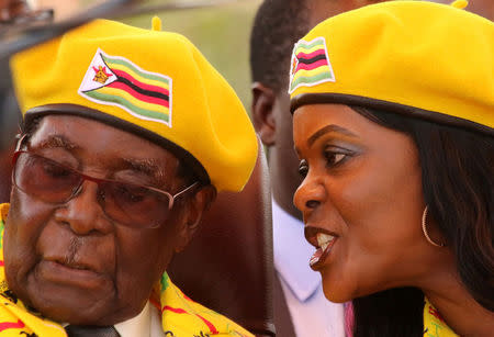 President Robert Mugabe listens to his wife Grace Mugabe at a rally of his ruling ZANU-PF party in Harare, Zimbabwe, November 8, 2017. REUTERS/Philimon Bulawayo/Files