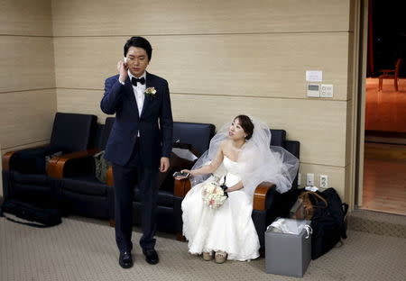 A bridal couple gets ready for their wedding ceremony at a budget wedding hall at the National Library of Korea in Seoul, South Korea, May 16, 2015. REUTERS/Kim Hong-Ji