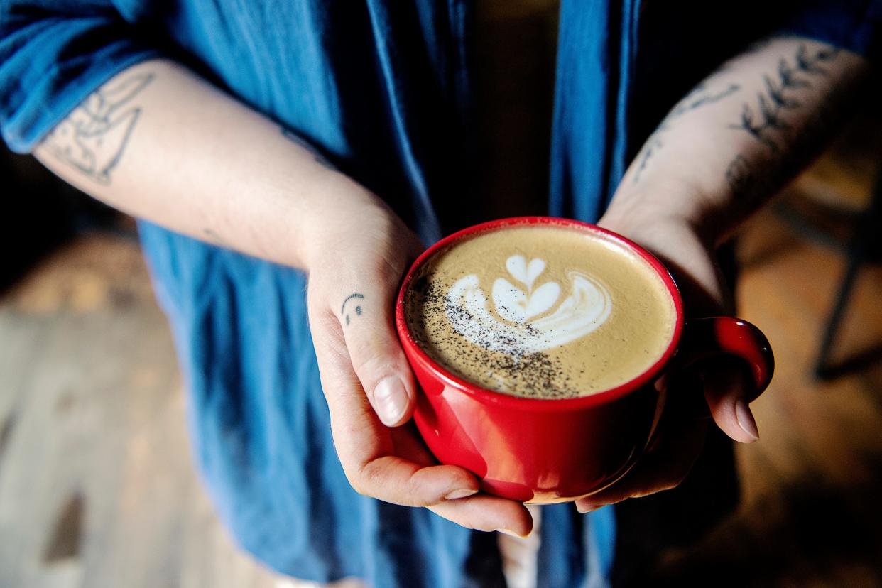 Robin Fredrickson, a manager at Odd’s Café in West Asheville, holds a Salted Maple Latte, September 7, 2023.