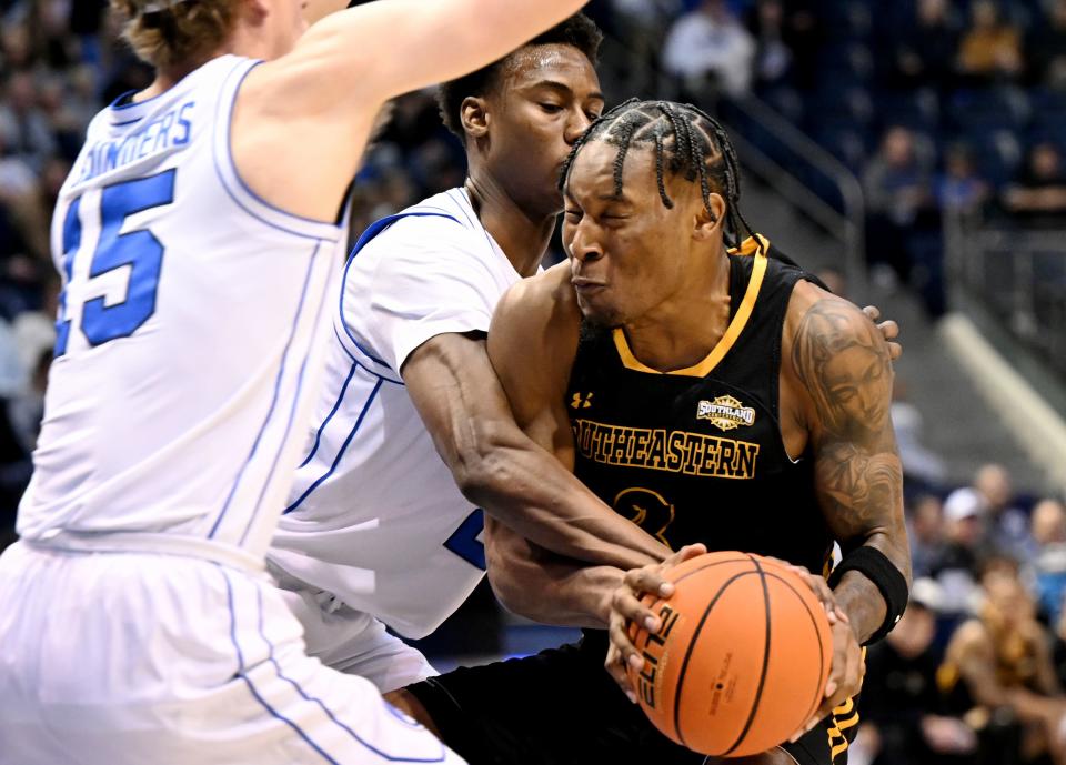 Brigham Young Cougars guard Richie Saunders (15) and Brigham Young Cougars guard Jaxson Robinson (2) defends Southeastern Louisiana Lions guard Roger McFarlane (3) as BYU and SE Louisiana play at the Marriott Center in Provo on Wednesday, Nov. 15, 2023. | Scott G Winterton, Deseret News