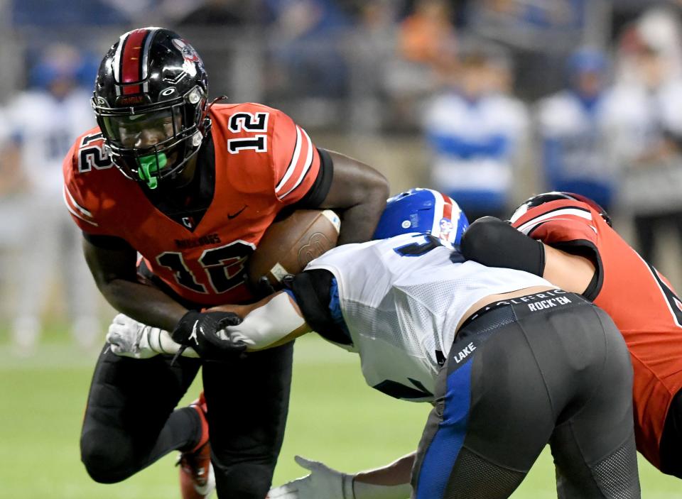 McKinley running back Nino Hill breaks a tackle for a gain in the first quarter against  Lake at Tom Benson Hall of Fame Stadium.   Friday, Sept 29, 2023.