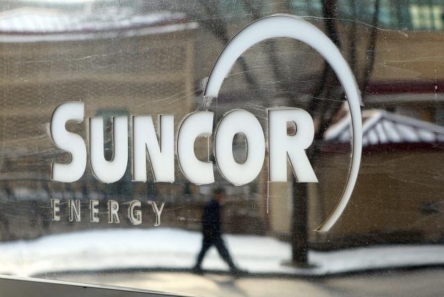 A pedestrian is reflected in a Suncor Energy sign in Calgary, Alberta, Monday, Feb. 1, 2010. The future was bubbling with uncertainty Monday for a major Canadian oil company with a big stake in Libya. And anyone looking for reassurance about the fate of Suncor&#39;s $3.5-billion investment in Libya&#x002019;s oil fields won&#x002019;t find it in the recent past. (AP Photo/ THE CANADIAN PRESS/Jeff McIntosh)